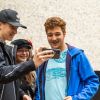 Drei Bonner Jugendliche schauen sich etwas auf einem Smartphone an